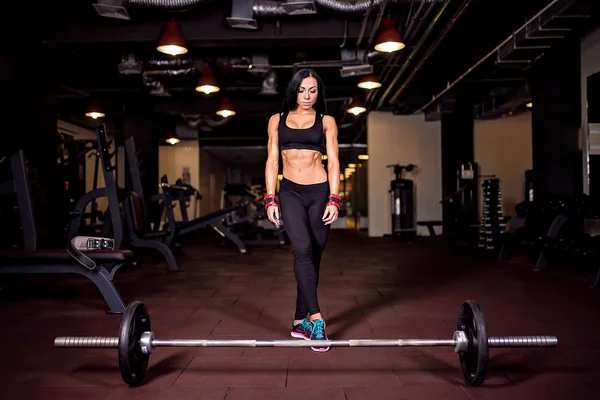 Svalnatý mladý fitness žena připravuje pro těžký tah cvičení v tělocvičně — Stock fotografie