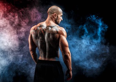 Siyah arka plan karşı sırtına dövme tanınmaz kaslı adam. İzole.