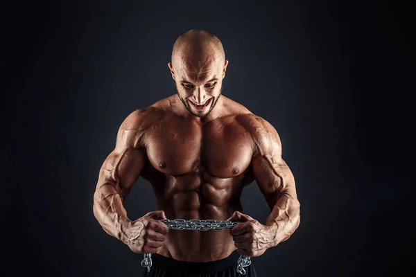 Portrait of aggressive bodybuilder trying to tear the metal chain — Stock Photo, Image