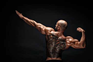 Siyah arka plan karşı sırtına dövme tanınmaz kaslı adam. İzole.