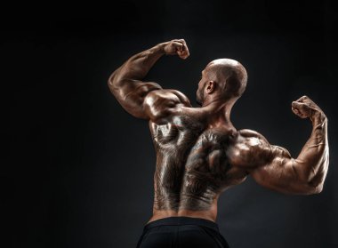 Siyah arka plan karşı sırtına dövme tanınmaz kaslı adam. İzole.