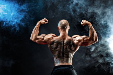 Siyah arka plan karşı sırtına dövme tanınmaz kaslı adam. İzole.