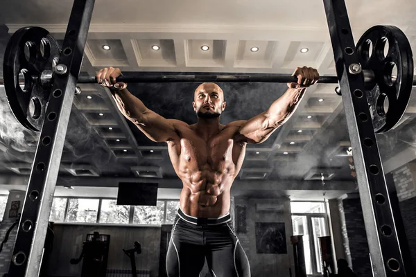 Calvo culturista preparando para el ejercicio con barra de pesas en el gimnasio — Foto de Stock