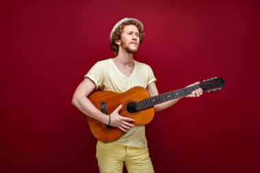 Gitar çalmak şapkalı kıvırcık saçlı adam