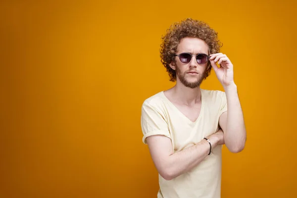 Hombre desconcertado en gafas de sol sobre fondo amarillo — Foto de Stock