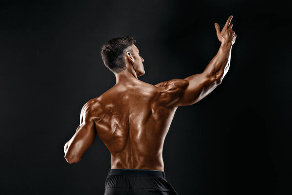 Back view of Unrecognizable man, strong muscles posing with arms up
