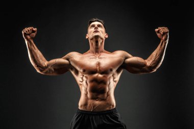 Vücut geliştirmeci poz. Güzel sportif adam erkek güç. Fitness adam kaslı. Seyir ve eller yukarı.