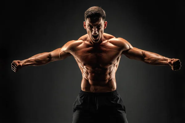 Bodybuilder poseren. Mooie sportieve vent mannelijke kracht. Fitness gespierde man. Brullen — Stockfoto