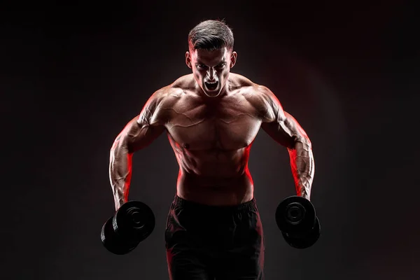 Концентрированный мускулистый человек делает упражнения с гантелями — стоковое фото