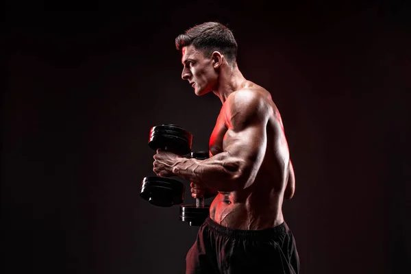 Hombre musculoso concentrado haciendo ejercicio con mancuerna — Foto de Stock
