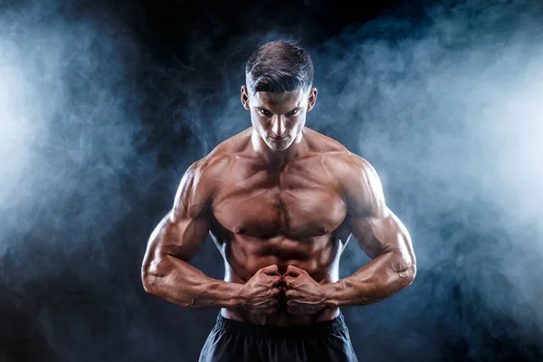 Hombre fuerte culturista con abdominales perfectos, hombros, bíceps, tríceps, pecho. — Foto de Stock