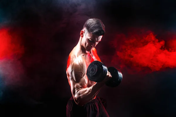 Concentrated muscular man doing exercise with dumbbell — Stock Photo, Image
