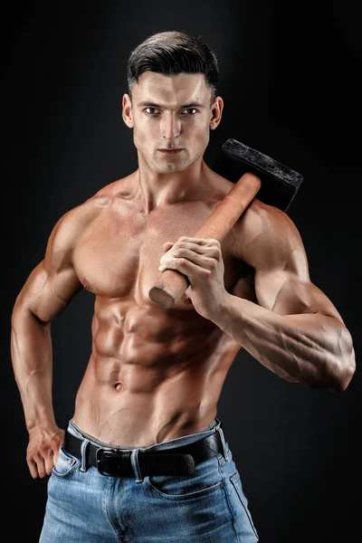 Uomo muscoloso con busto nudo che regge un grosso ronzio. Isolato su fondo grigio scuro — Foto Stock