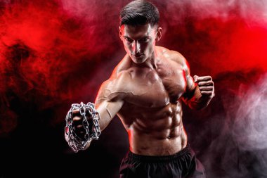 Yumruğunu üzerinde örgülü zincirlerle yumruk yaparken ciddi kas avcı.