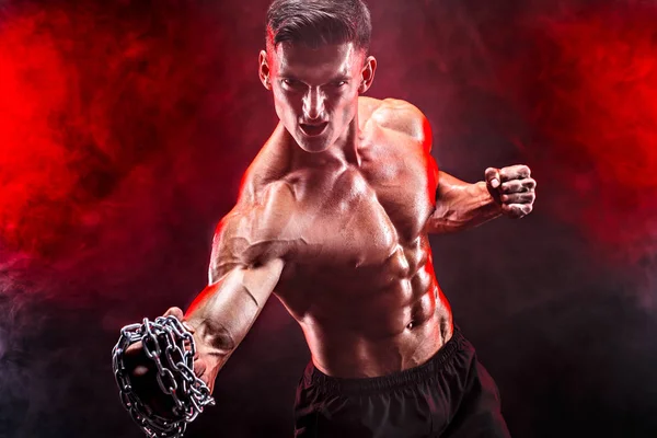 Serio luchador muscular haciendo el puñetazo con las cadenas trenzadas sobre su puño . — Foto de Stock