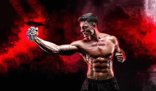 Yumruğunu üzerinde örgülü zincirlerle yumruk yaparken ciddi kas avcı.