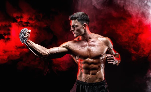 Yumruğunu üzerinde örgülü zincirlerle yumruk yaparken ciddi kas avcı.