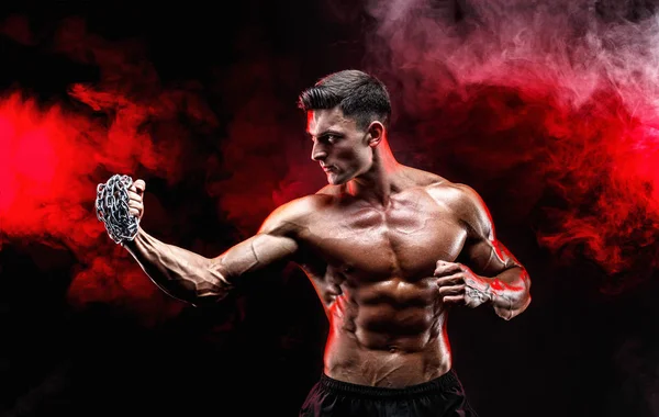 Serio luchador muscular haciendo el puñetazo con las cadenas trenzadas sobre su puño . — Foto de Stock