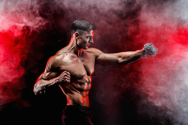 Serio luchador muscular haciendo el puñetazo con las cadenas trenzadas sobre su puño . — Foto de Stock