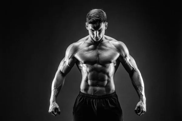 A testépítő pózol. Gyönyörű sportos férfi erő. Fitness izmos ember — Stock Fotó