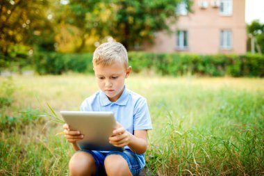 Daşu avlu ve tablet PC'de oyun genç çocuk.