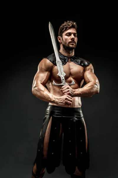 Kılıçlı, deri kostümlü bir barbar. — Stok fotoğraf