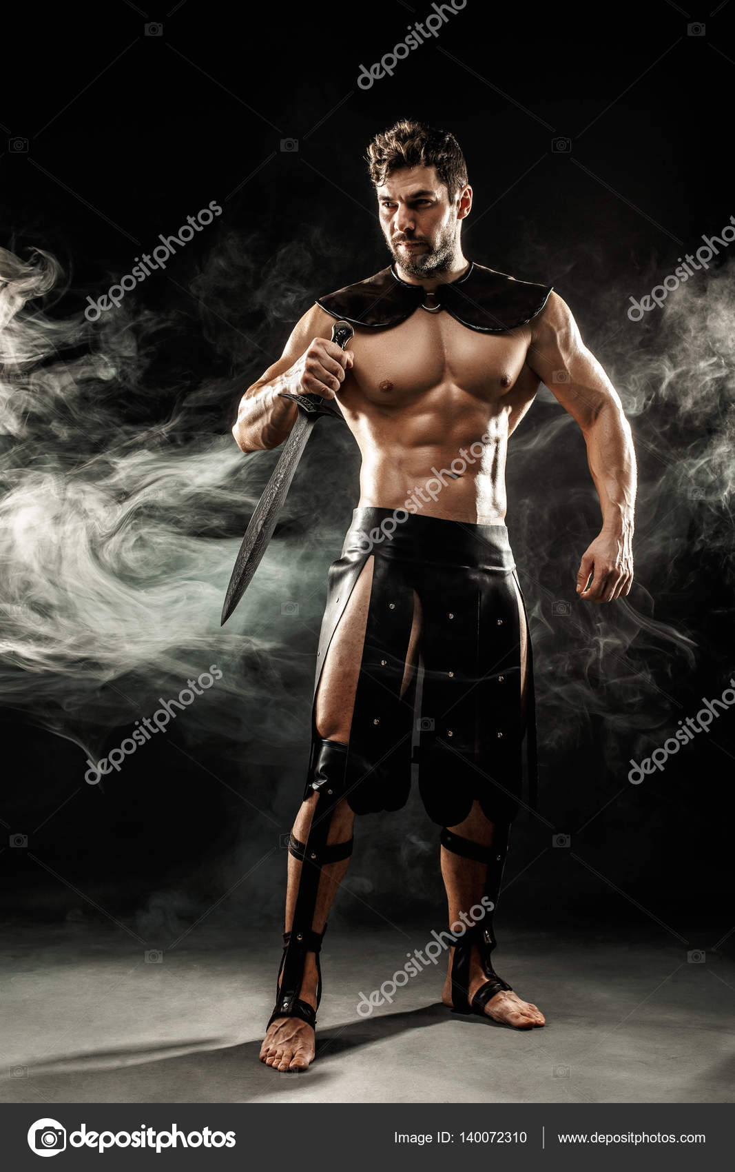 Severe barbarian in leather costume with sword in smoke Stock Photo by  ©zamuruev 140072310