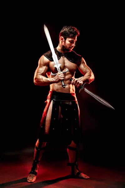 Severe barbarian in leather costume with sword in smoke — Stock Photo, Image