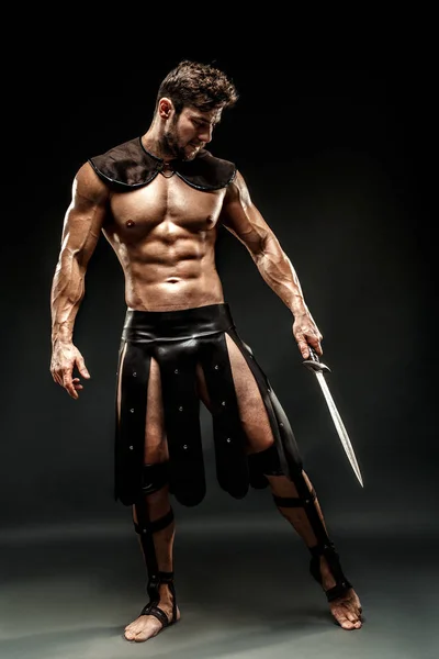 Severe barbarian in leather costume with sword — Stock Photo, Image