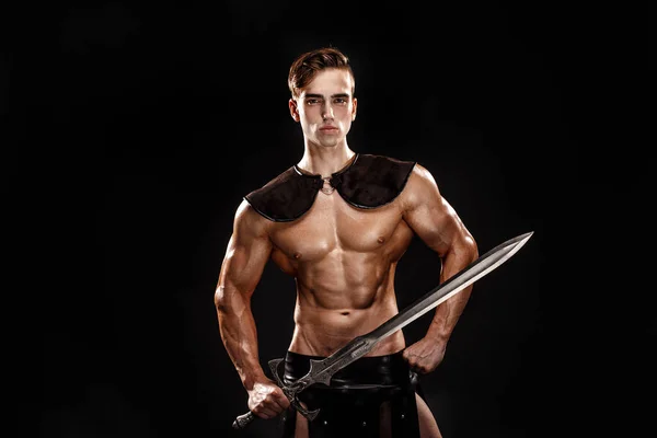 Szép izmos Gladiátor karddal portréja. Elszigetelt. Stúdió felvétel. Fekete háttér — Stock Fotó