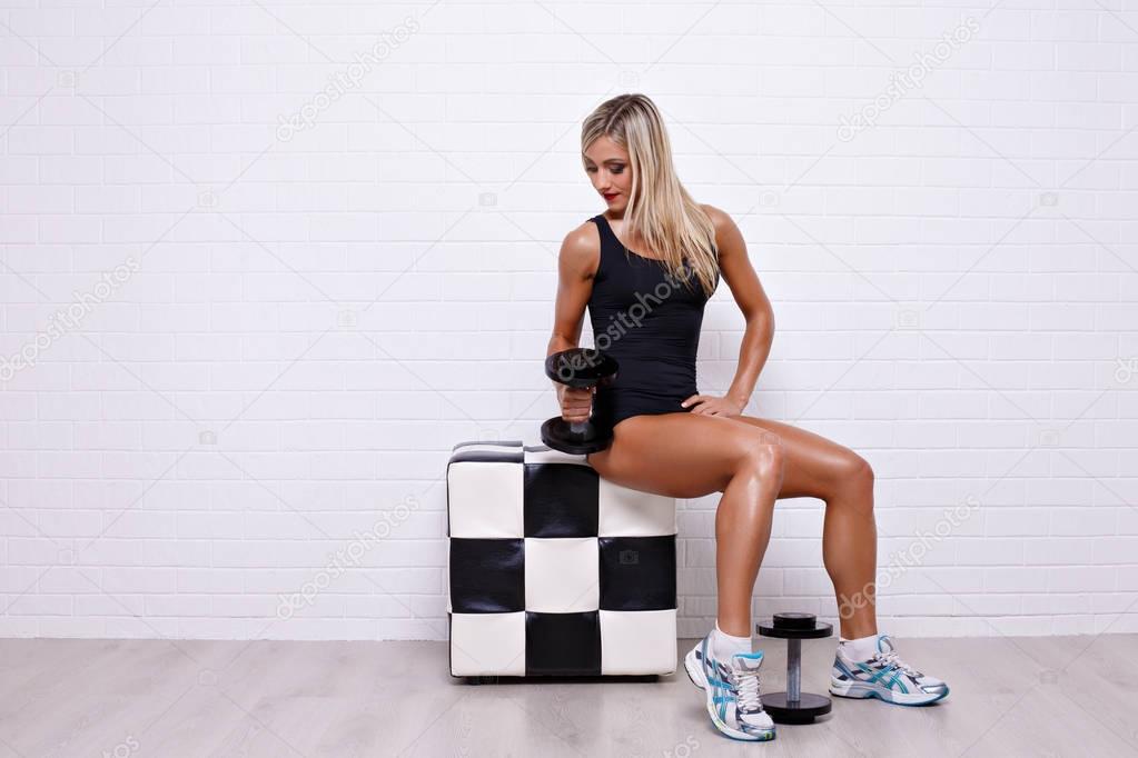 Sexy blonde posing with dumbbells