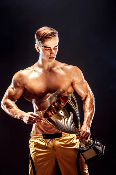 Bodybuilding-Meister mit Pokal. — Stockfoto