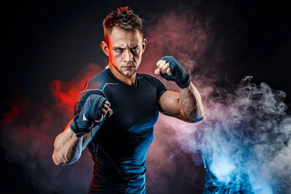 Estúdio retrato de lutando contra o homem muscular na fumaça — Fotografia de Stock