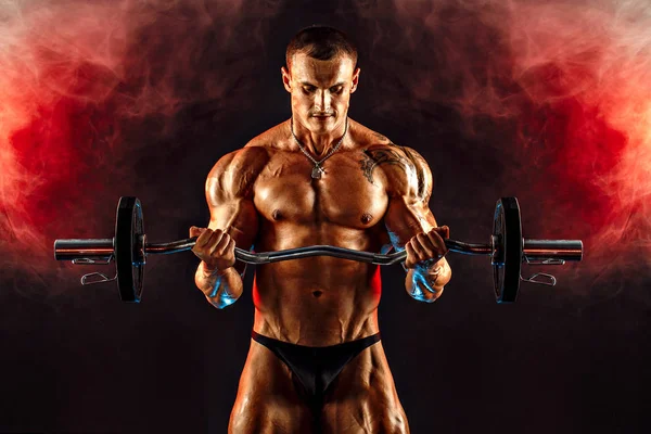 Strong sportsman lifting heavy dumbbell in smoke — Stock Photo, Image