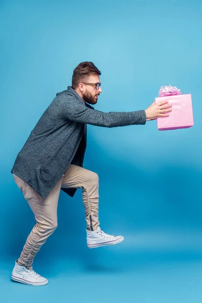 Чоловік позує комічно з подарунковою коробкою — стокове фото