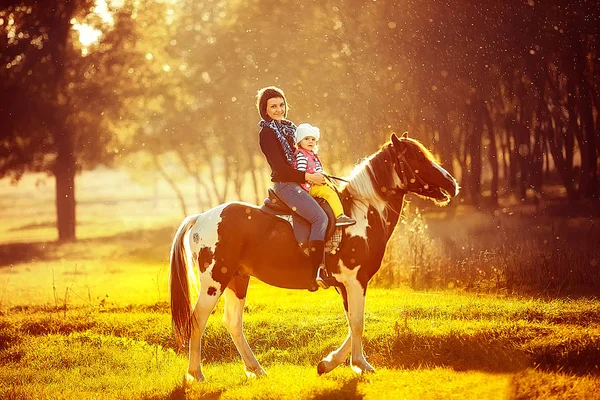 Mãe e filha montando um cavalo — Fotografia de Stock
