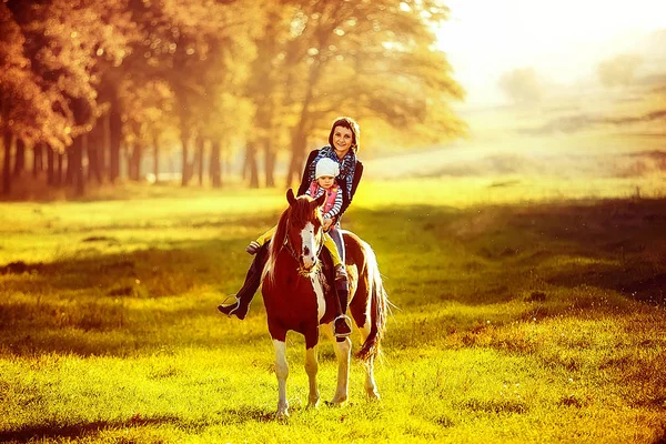 Mãe e filha montando um cavalo — Fotografia de Stock