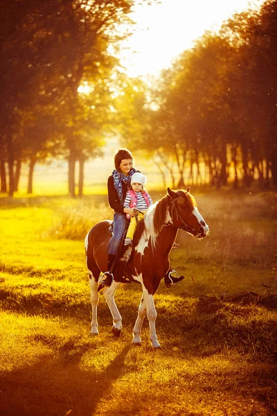 Moeder en dochter rijden een paard — Stockfoto