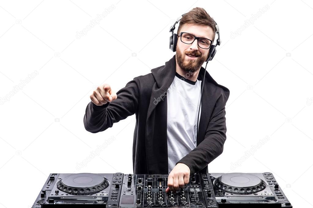 Trendy male dj posing against mixing console