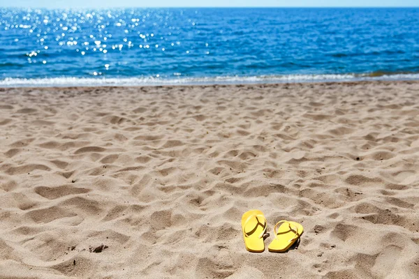Zapatillas de playa amarillas en la playa de arena, verano, baño — Foto de Stock