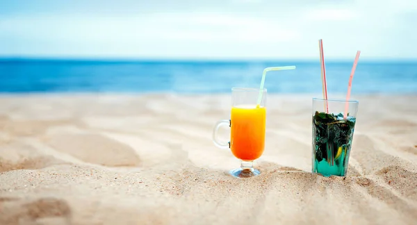 Two glasses of Fresh mojito and Juice cocktail on blurred seascape background — Stock Photo, Image