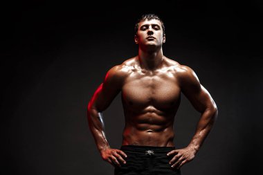 Stüdyoda siyah arka planda poz veren yakışıklı erkek model..