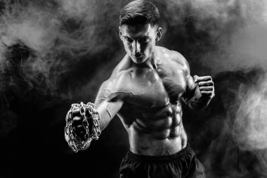 Yumruğunu üzerinde örgülü zincirlerle yumruk yaparken ciddi kas avcı.