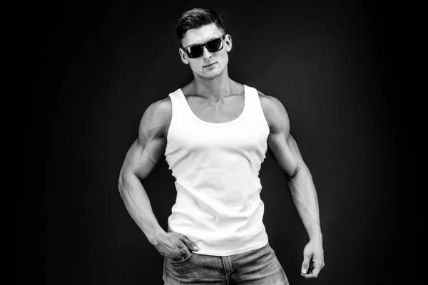 Przystojny mięśni mężczyzna w ciemnych okularach i białej koszuli. — Zdjęcie stockowe