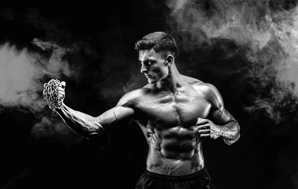 Serios luptător muscular face pumnul cu lanțurile împletite peste pumnul său . — Fotografie, imagine de stoc