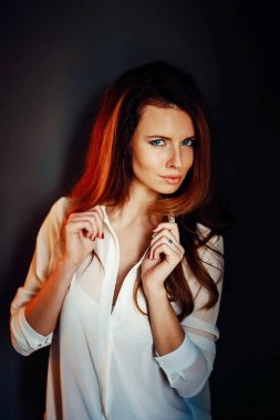 Güzel kız koyu mavi duvara yakın karanlıkta ayakta