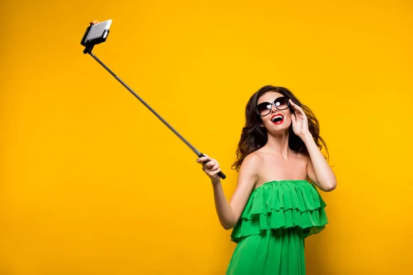 Bruneta, takže selfie v sluneční brýle a zelené šaty. — Stock fotografie