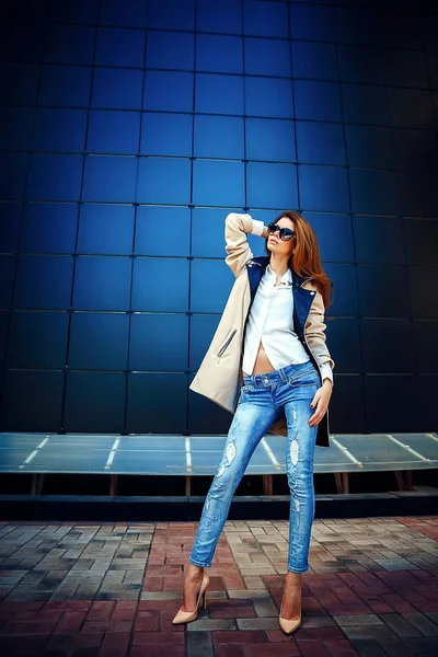 Meisje in een beige vacht en blue jeans — Stockfoto