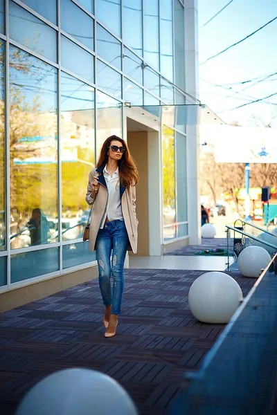 Chica en un abrigo beige y vaqueros azules — Foto de Stock