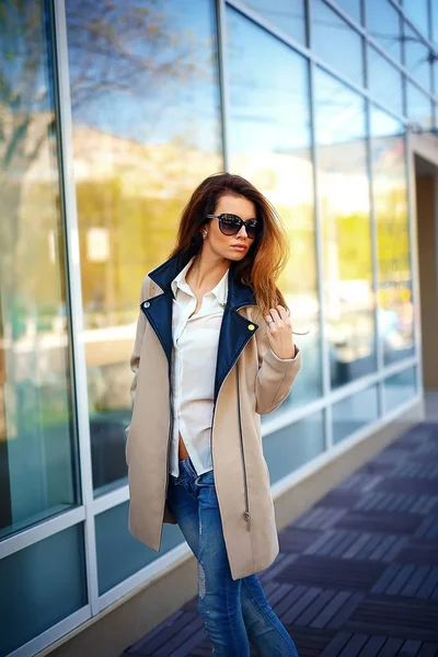 Chica en un abrigo beige y vaqueros azules — Foto de Stock